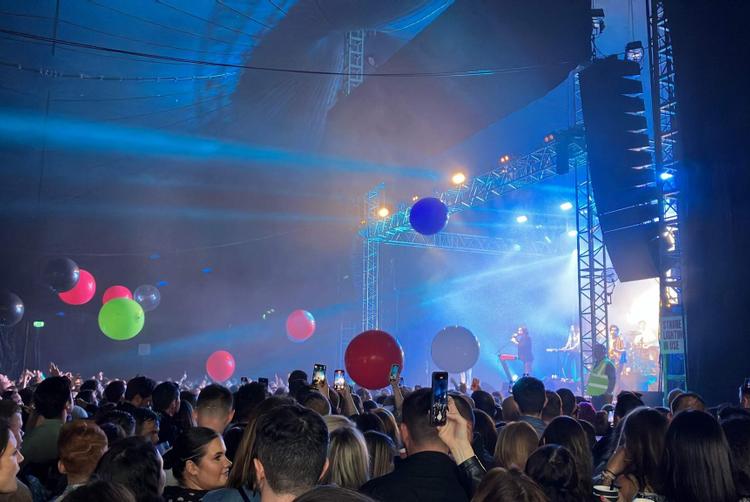 Crowd gathered at a lively outdoor concert during the Galway Arts Festival, with colourful balloons and stage lights.