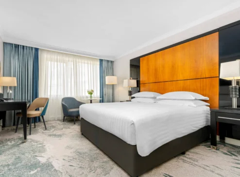 Modern hotel room with king-sized bed, seating area, and large window at The Galmont Hotel & Spa.