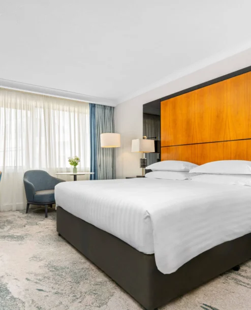 Modern hotel room with king-sized bed, seating area, and large window at The Galmont Hotel & Spa.