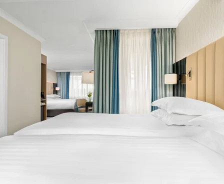 Elegant hotel room with plush white bedding and a serene view.