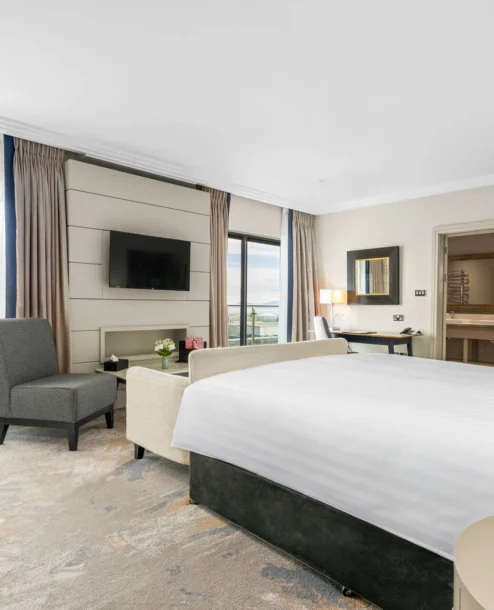 Elegant hotel room with a sea view and cosy seating area.