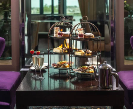 Elegant afternoon tea setup in a cosy hotel lounge with tiered trays of treats.