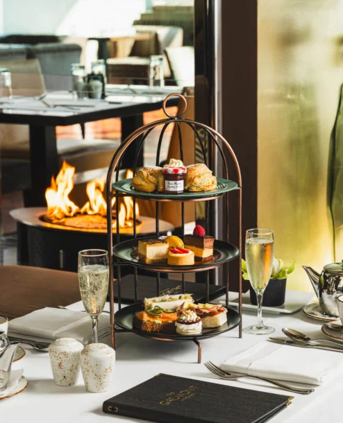 Afternoon tea setup by cosy fireplace at The Galmont Hotel & Spa, perfect for families or couples.