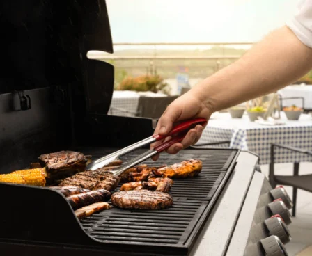 Grilling meats and corn on a barbecue at The Galmont Hotel's outdoor terrace.