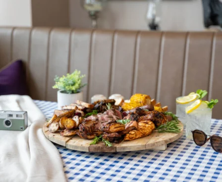 A delicious barbecue platter on a table, surrounded by drinks and decor, inviting setting.