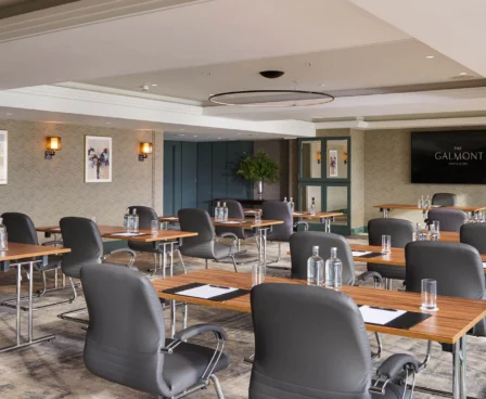 Modern meeting room at The Galmont Hotel with tables, chairs, and presentation setup.