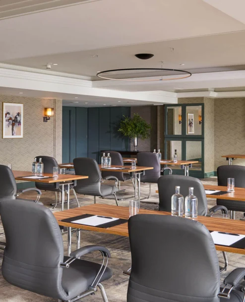 Modern meeting room at The Galmont Hotel with tables, chairs, and presentation setup.