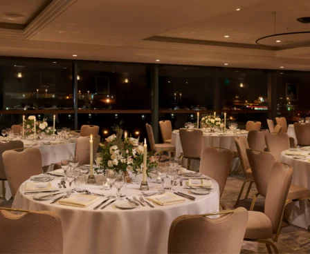 Elegant dining area set for a romantic evening, with softly lit tables and floral centrepieces.