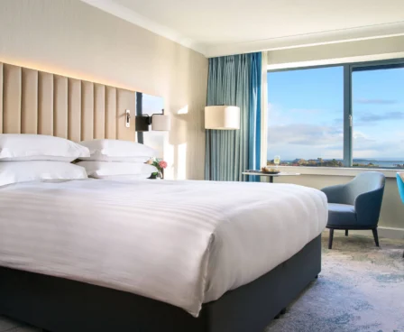 Elegant hotel room with a king-size bed, ocean view and cosy seating area at The Galmont Hotel.