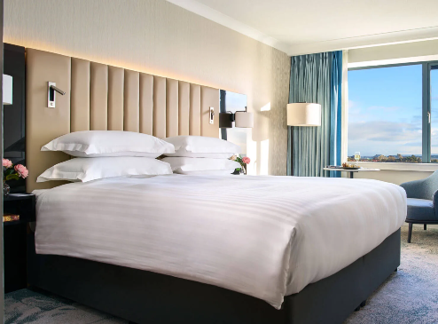 Elegant hotel room with a king-size bed, ocean view and cosy seating area at The Galmont Hotel.