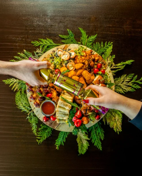 Festive appetiser platter with two people sharing, decorated with greenery at The Galmont Hotel.