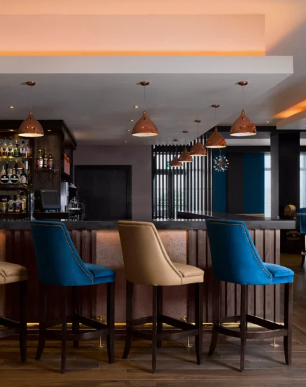 Contemporary hotel bar with elegant seating and warm lighting, welcoming for guests.