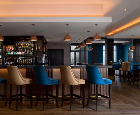 Contemporary hotel bar with elegant seating and warm lighting, welcoming for guests.