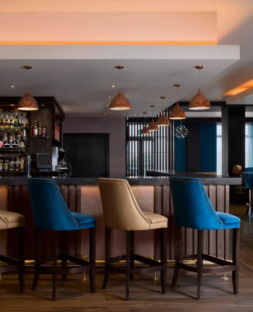 Contemporary hotel bar with elegant seating and warm lighting, welcoming for guests.