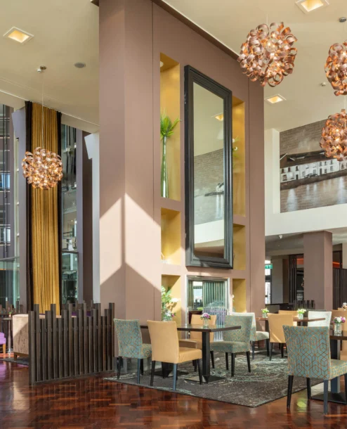Modern hotel lobby with elegant seating and artistic lighting, welcoming atmosphere.