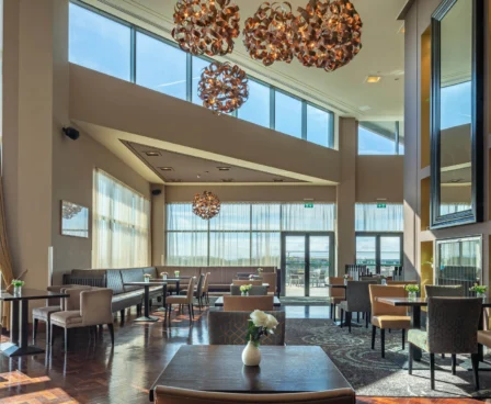 Spacious hotel dining area with elegant decor and scenic lake views.