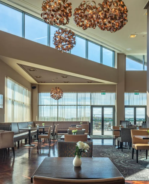 Spacious hotel dining area with elegant decor and scenic lake views.