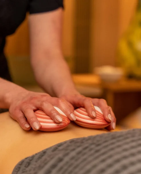 Relaxing spa massage at The Galmont Hotel & Spa, featuring warm shell stones.