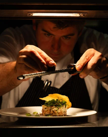 Chef artfully preparing a gourmet dish at The Galmont Hotel.