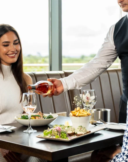A family enjoying a meal at The Galmont Hotel & Spa with a waiter serving drinks.