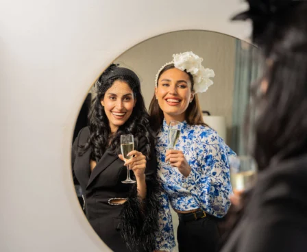 Two women smiling with champagne, preparing for a special event at The Galmont Hotel.