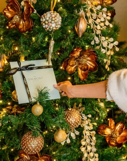 Family decorating Christmas tree with gold ornaments at The Galmont Hotel & Spa.