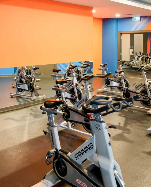 Families enjoy cycling in The Galmont Hotel's vibrant indoor gym with colourful murals.