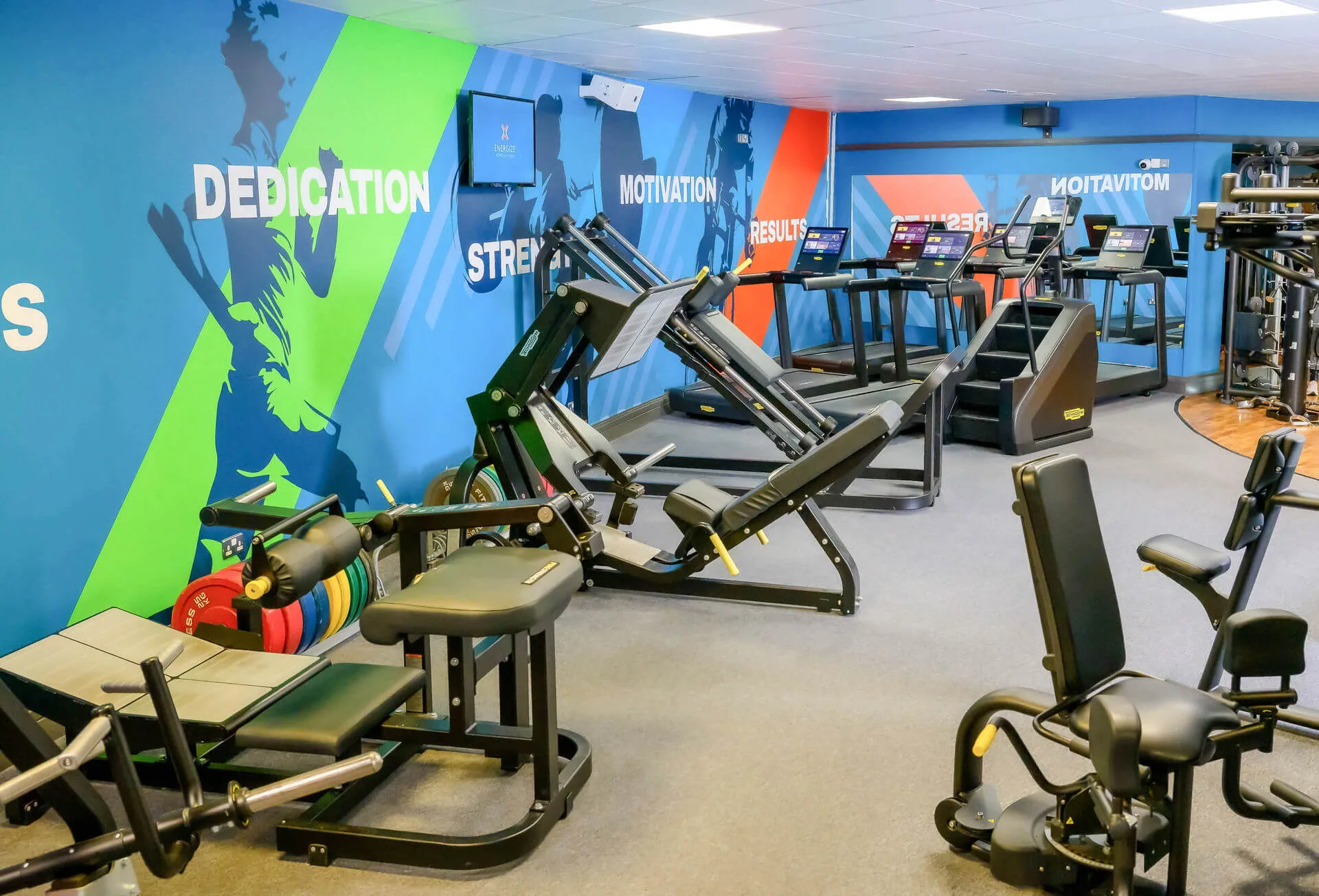 Family enjoying workout in vibrant hotel gym, with colourful walls and modern equipment.