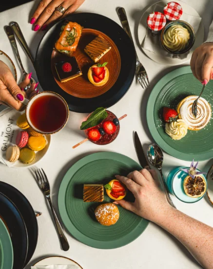 A family enjoying afternoon tea with pastries at a chic and cosy table.