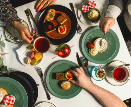 A family enjoying afternoon tea with pastries at a chic and cosy table.