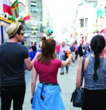 Group exploring vibrant street near The Galmont Hotel, adorned with colourful shops.