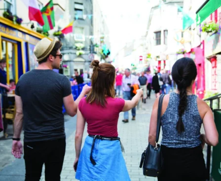 Group exploring vibrant street near The Galmont Hotel, adorned with colourful shops.