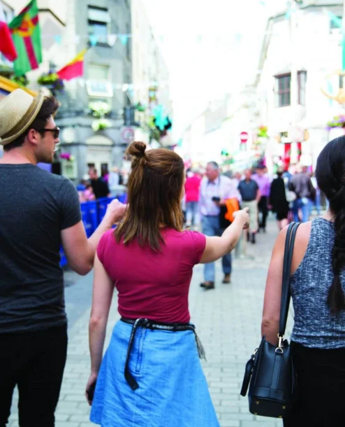 Group exploring vibrant street near The Galmont Hotel, adorned with colourful shops.