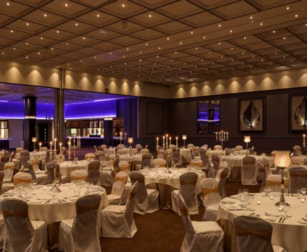 Elegant hotel ballroom set for an evening event with candlelit tables.