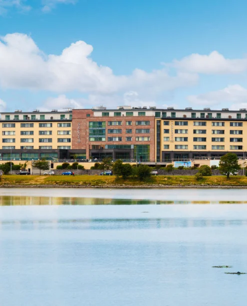 Family enjoying a stay at The Galmont Hotel & Spa beside a tranquil lake on a sunny day.