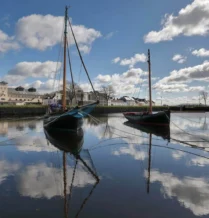 Scenic view of boats on a calm harbour near The Galmont Hotel & Spa under a cloudy sky.