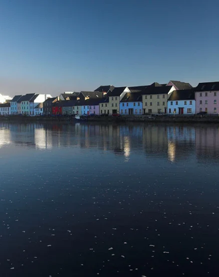 Vibrant waterfront houses reflected in calm waters near The Galmont Hotel & Spa.