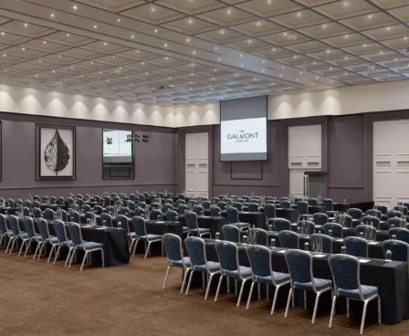 Spacious conference room at The Galmont Hotel & Spa with rows of seating and presentation screens.