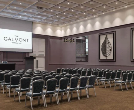 Conference room at The Galmont Hotel set up for a meeting with rows of chairs and a presentation screen.