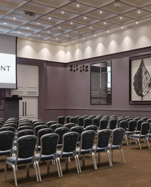 Conference room at The Galmont Hotel set up for a meeting with rows of chairs and a presentation screen.