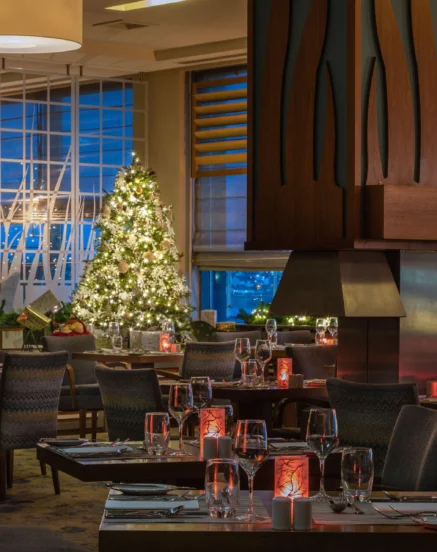 Cosy hotel restaurant with festive holiday decorations and ambient lighting.
