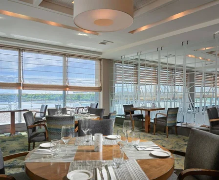 Elegant hotel restaurant with sea views, set for a family meal, large windows and natural light.