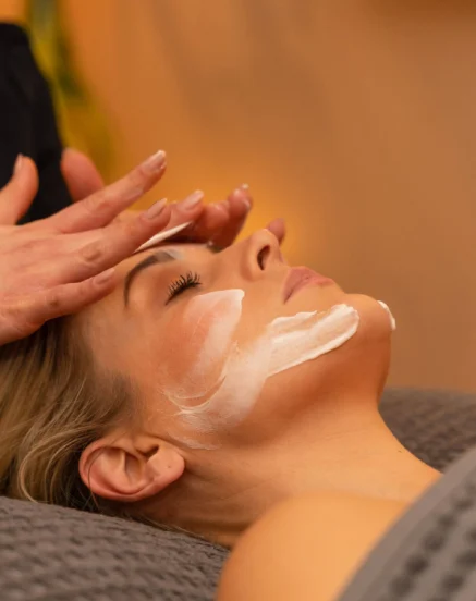 Woman enjoys a relaxing facial treatment at a spa, creating a serene atmosphere.