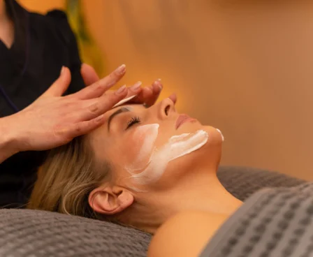 Woman enjoys a relaxing facial treatment at a spa, creating a serene atmosphere.