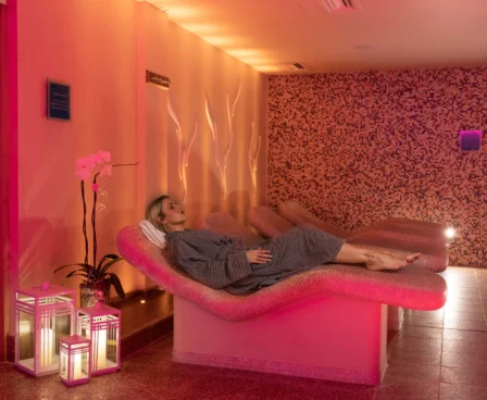 Woman relaxing on a spa lounger in a warmly lit room at The Galmont Hotel & Spa.
