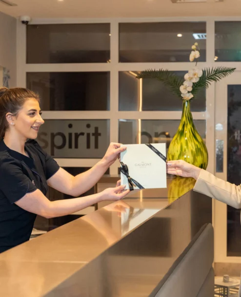 Guest receiving a brochure from receptionist at The Galmont Hotel lobby.