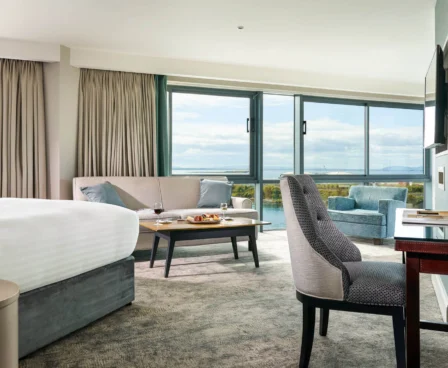Spacious hotel room with sea view, cosy seating area, and elegant décor at The Galmont Hotel.