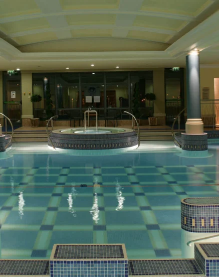 Family enjoying indoor pool and spa at The Galmont Hotel, warm lighting and elegant design.