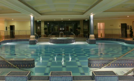 Family enjoying indoor pool and spa at The Galmont Hotel, warm lighting and elegant design.