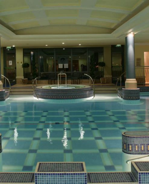 Family enjoying indoor pool and spa at The Galmont Hotel, warm lighting and elegant design.